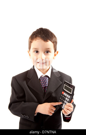 Small boy wearing a dark business suit and holding a calculator, against a white background. Stock Photo