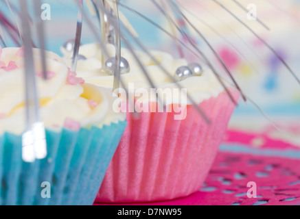 two cupcakes in blue and pink cases on doily Stock Photo