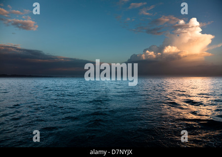 The rising sun catches early morning cumulus cloud forming over northern Corfu Stock Photo