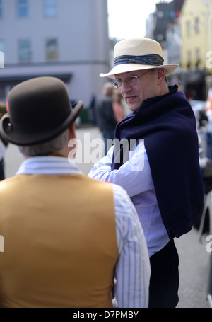 Two men with hats talking in the street Stock Photo
