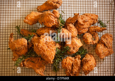 Fried chicken pieces cooling on a rack Stock Photo