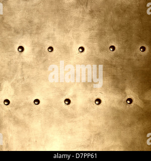 Gold grunge metal plate or armour texture with rivets as background square format Stock Photo