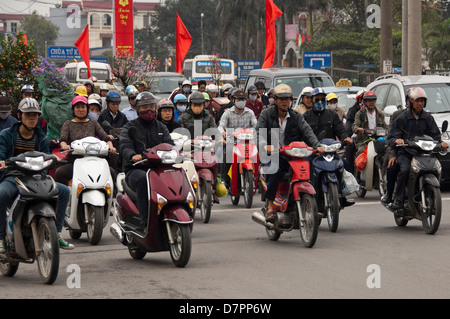 Horizontal street view of lots of mopeds laden with people and belongings all heading home for the Tet holidays. Stock Photo