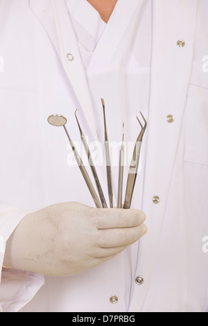 dentists hands in white medical gloves with dental tools Stock Photo