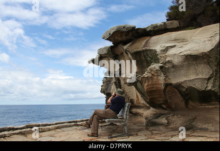 Man whale-spotting on part of the Bondi to Coogee Walk in Australia Stock Photo