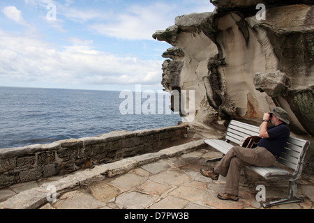 Man whale-spotting on part of the Bondi to Coogee Walk in Australia Stock Photo