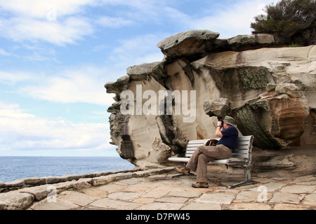 Man whale-spotting on part of the Bondi to Coogee Walk in Australia Stock Photo