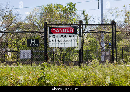 High voltage warning sign on fence Stock Photo