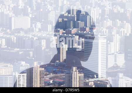 Double exposure of man over cityscape, rear view Stock Photo