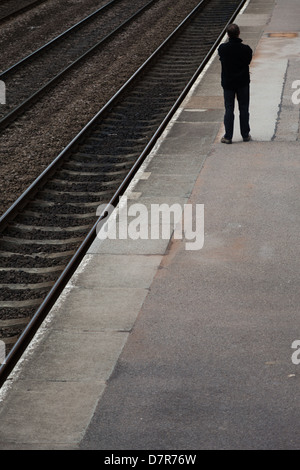 Man waiting on railway platform Stock Photo