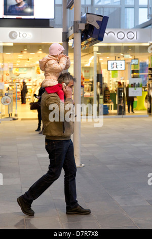 man on phone toddler on shoulders Stock Photo