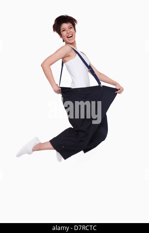 Girl in oversized pants jumping Stock Photo