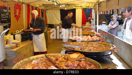 Men cook and sell various meat snacks in a stall on a medieval market held during medieval festival in Compiegne. Stock Photo