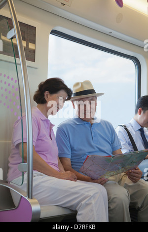 Mature couple sitting in the subway and looking at the map Stock Photo