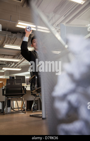 Businessman preparing to throw paper into wastebasket Stock Photo
