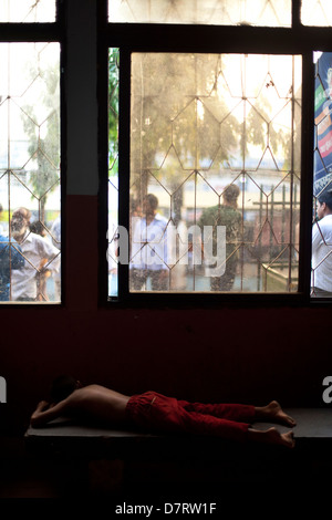 A homeless child asleep at the Sadarghat ferry terminal, Dhaka, Bangladesh Stock Photo