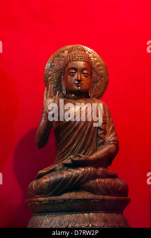 Buddha wooden statue in red background Stock Photo