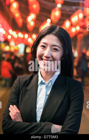 Businesswoman standing on the street, red lanterns on the background Stock Photo