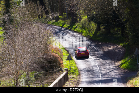 Car driving along a country road in the sunshine Stock Photo