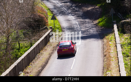 Car driving along a country road in the sunshine Stock Photo