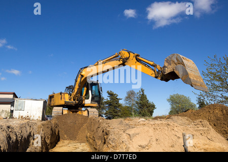 an excavator digging a trench at a construction site, top view from a ...