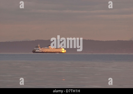 USA, WA, Edmonds. Washington State Ferry approaches from Kingston with sunrise light coming over Cascade Mountains