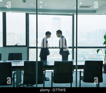 Two Businessmen Bowing to Each Other Stock Photo