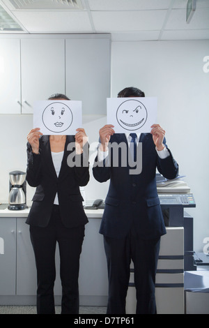 Businesspeople Holding Happy Faces on Paper Stock Photo