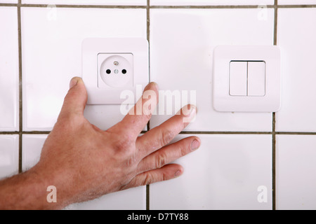 Man fitting a continental wall socket Stock Photo