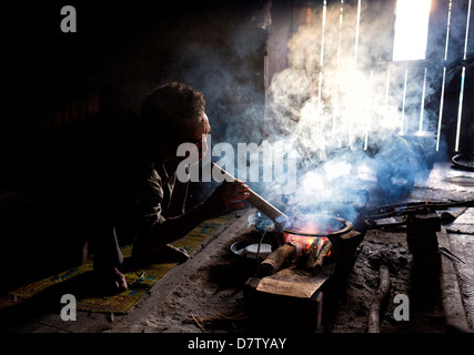 Man of the Palaung tribe cooking on open fire in his home in village near Kengtung (Kyaingtong), Shan State, Burma Stock Photo