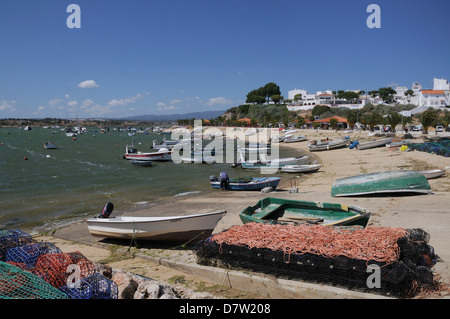 Lobster pots on quayside next to moored fishing boats, Alvor, near Portimao, Algarve, Portugal Stock Photo