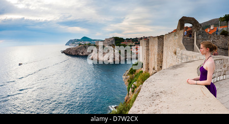 Tourist on Dubrovnik City Walls, with Fort Lovrijenac in the background, Dubrovnik, Dalmatian Coast, Adriatic, Croatia Stock Photo