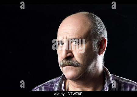 Bald man with a big mustache expressing uncertainty and fear Stock Photo