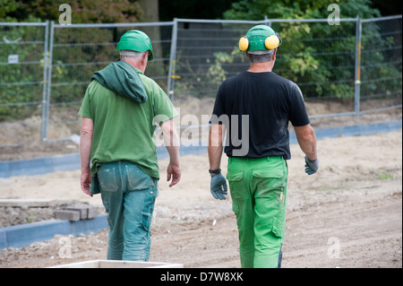 Two construction workers are walking on a building site Stock Photo