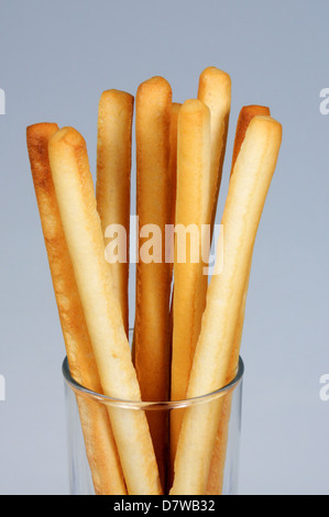 Grissini Friabili bread sticks in a clear glass against a grey background. Stock Photo