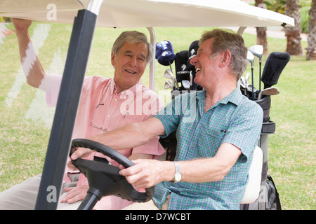 Two elderly men having a laugh on a golf buggy Stock Photo