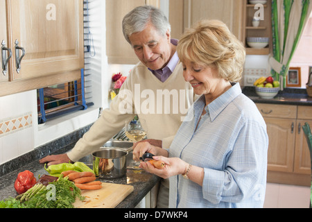 Elderly couple in their kitchen preparing a meal Stock Photo