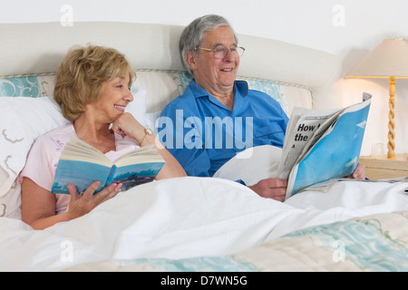 Elderly couple reading in their bed Stock Photo