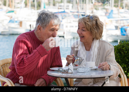 Elderly couple having a coffee in a seafront cafe Stock Photo