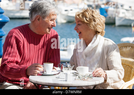 Elderly couple having a coffee in a seafront cafe Stock Photo