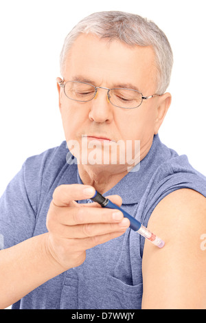 Middle aged man injecting insulin in his arm, isolated on white background Stock Photo