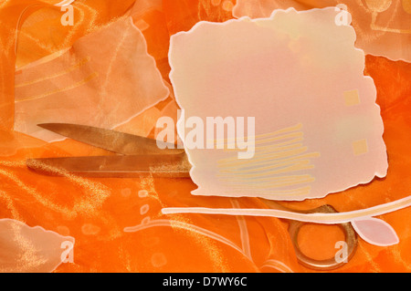 Sewing elements - bright orange organza and scissors. Stock Photo