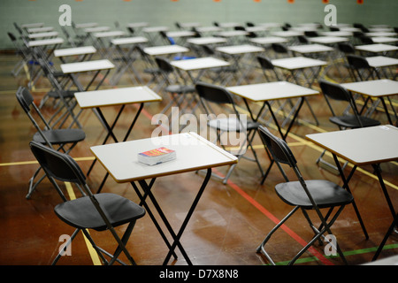 desks set out in a school hall in preparation for exam empty tables Stock Photo