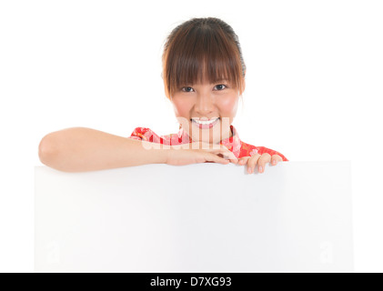 Portrait of smiling Chinese Asian woman in red cheongsam showing blank space on banner, isolated on white background Stock Photo