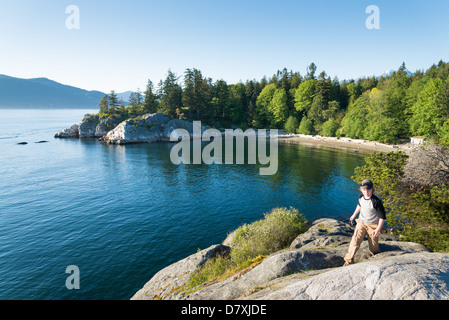 Boy clambers up rock at Whyte Island, Whytecliff Park, West Vancouver, British Columbia, Canada Stock Photo