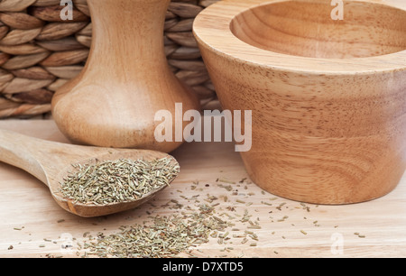 Chopped rosemary in rustic kitchen scene with wooden utensils Stock Photo