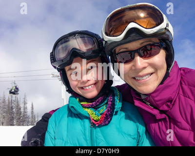 Mother and daughter wearing ski gear on mountain Stock Photo