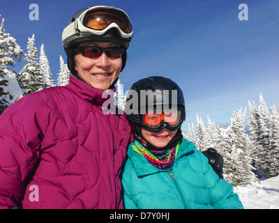 Mother and daughter wearing ski gear outdoors Stock Photo