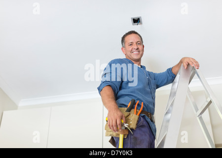 Man working on ceiling lights Stock Photo