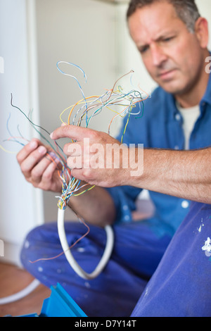 Electrician examining wires in kitchen Stock Photo